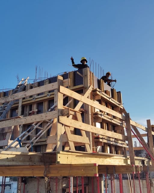 Equipo trabajando en una obra grande con encofrados de madera